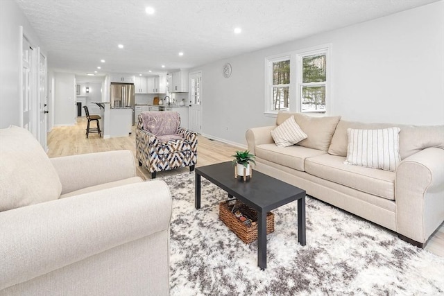 living room with sink and light hardwood / wood-style floors