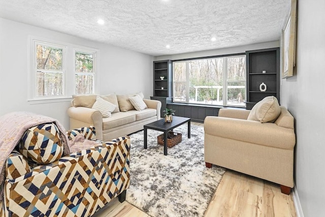 living room featuring light hardwood / wood-style floors and a textured ceiling