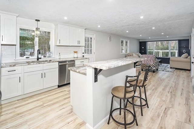 kitchen with white cabinetry, stainless steel dishwasher, and sink