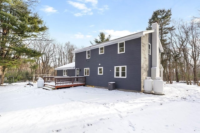 snow covered property featuring central AC unit and a deck