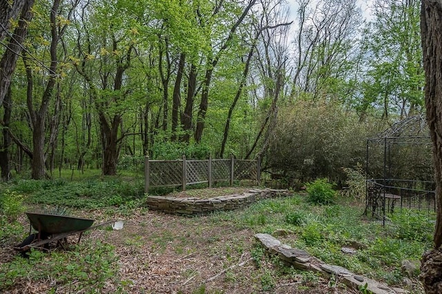 view of yard with fence and a view of trees
