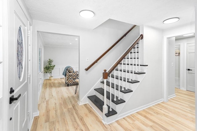 entrance foyer featuring light hardwood / wood-style flooring and a textured ceiling