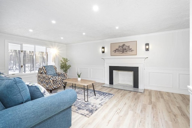 living room with crown molding, a textured ceiling, and light hardwood / wood-style flooring