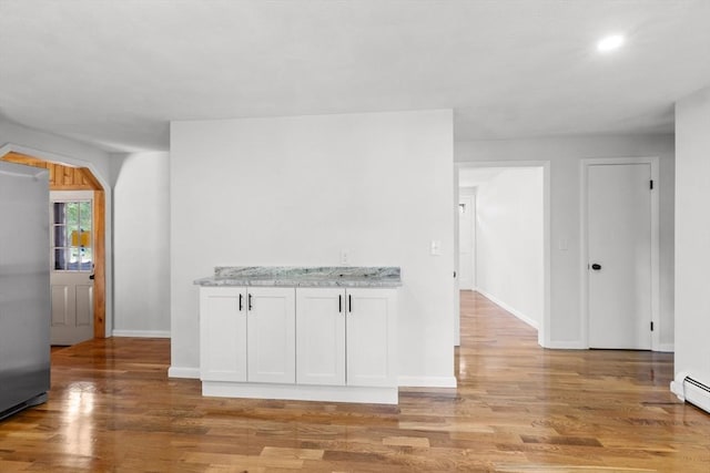 6 Walter St, Norton, MA 02766 - kitchen with stainless steel refrigerator, light wood-style floors, baseboards, light stone counters, and white cabinetry