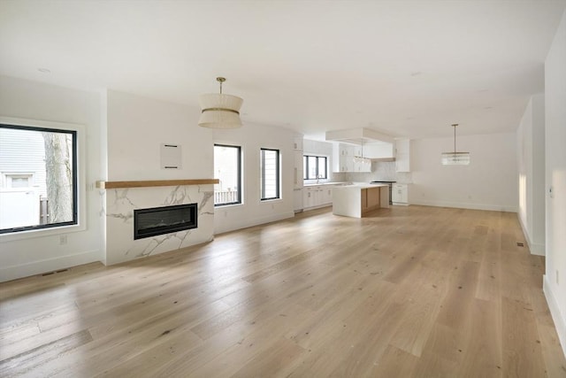230 Auburn St Unit 230, Newton, MA 02466 - unfurnished living room featuring a premium fireplace, light wood finished floors, and baseboards