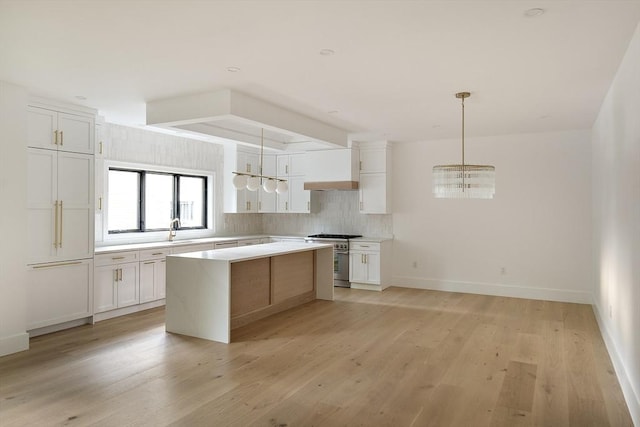 230 Auburn St Unit 230, Newton, MA 02466 - kitchen featuring high end stove, a chandelier, decorative backsplash, light countertops, and white cabinetry
