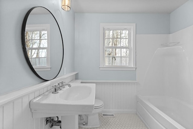 230 Gosnold St Unit 11Abc, Barnstable, MA 02601 - full bathroom featuring washtub / shower combination, tile patterned floors, visible vents, toilet, and wainscoting