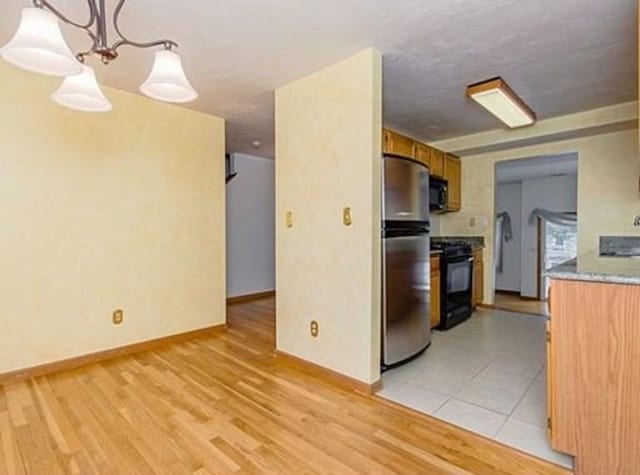 6 Tisdale Dr Unit 6, Dover, MA 02030 - kitchen with black appliances, light wood-type flooring, brown cabinets, and light countertops