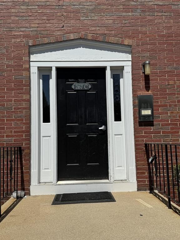 property entrance featuring brick siding