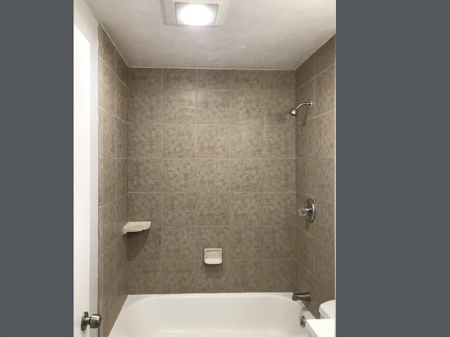 bathroom featuring bathing tub / shower combination and toilet
