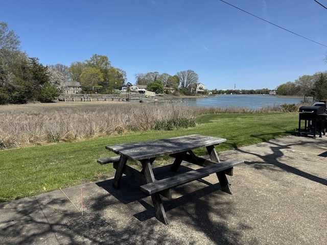 view of home's community with a water view and a yard