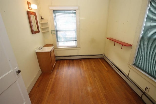 57 Edgewater Rd-, Waterfront, Hull, MA 02045 - empty room featuring a baseboard heating unit, wood finished floors, and a sink