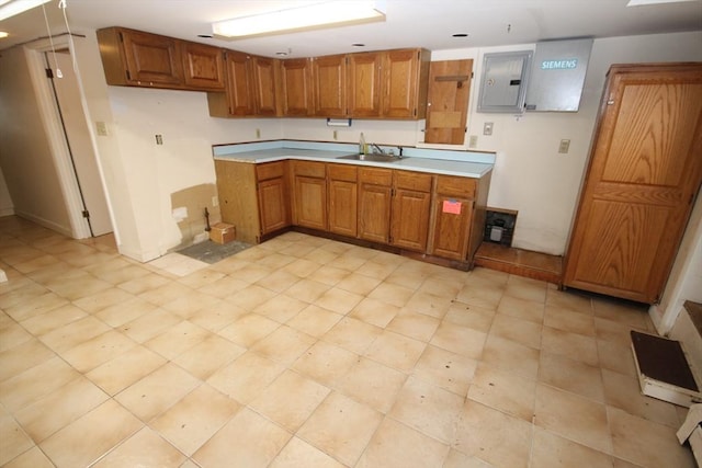 57 Edgewater Rd-, Waterfront, Hull, MA 02045 - kitchen with electric panel, brown cabinetry, light countertops, and a sink