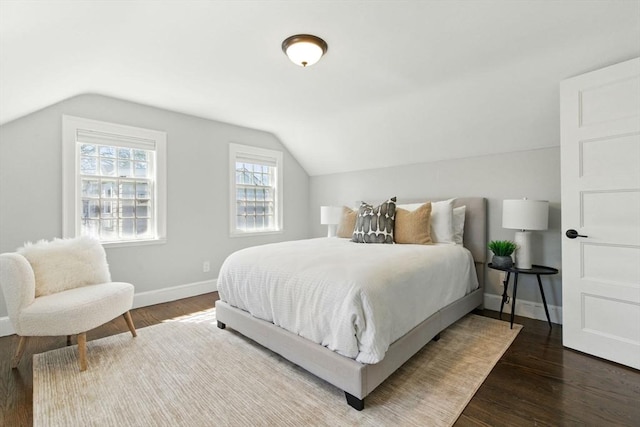 bedroom with baseboards, wood finished floors, and lofted ceiling