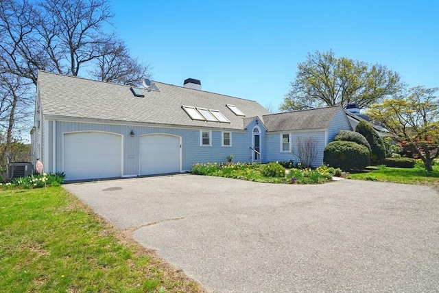 view of front of home featuring roof with shingles, a chimney, an attached garage, central air condition unit, and driveway