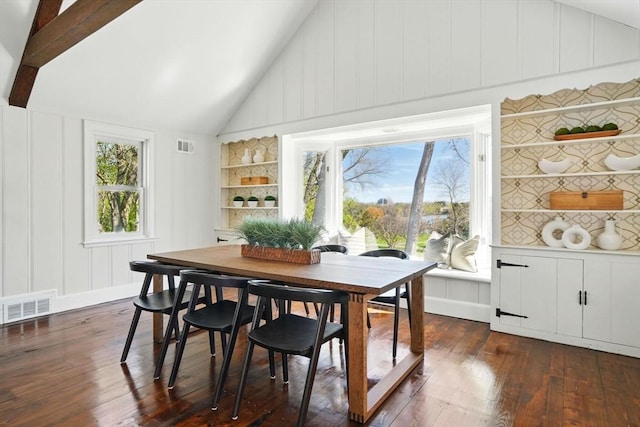 dining room featuring visible vents, dark wood-type flooring, a decorative wall, and high vaulted ceiling