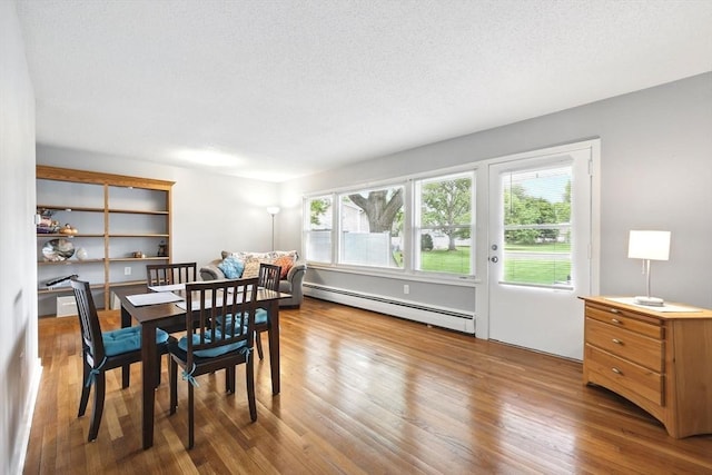 2500 Pendleton Ave Unit 2500, Chicopee, MA 01022 - dining space featuring a baseboard radiator, wood finished floors, and a textured ceiling