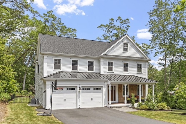 306 Laws Brook Rd, Concord, MA 01742 - view of front facade featuring a porch, a standing seam roof, a garage, asphalt driveway, and central air condition unit