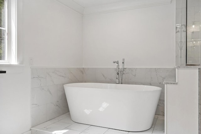 306 Laws Brook Rd, Concord, MA 01742 - full bathroom featuring marble look tile flooring, tile walls, a freestanding tub, and a wainscoted wall