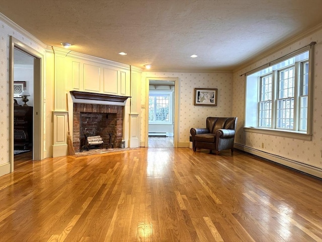 unfurnished room featuring crown molding, light wood-type flooring, a textured ceiling, and a brick fireplace