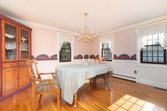 dining space with crown molding, a chandelier, light hardwood / wood-style flooring, and a baseboard heating unit