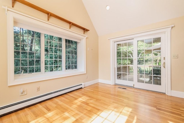 unfurnished room featuring baseboard heating, light wood-type flooring, and lofted ceiling