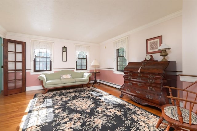 sitting room featuring light hardwood / wood-style floors, baseboard heating, and ornamental molding