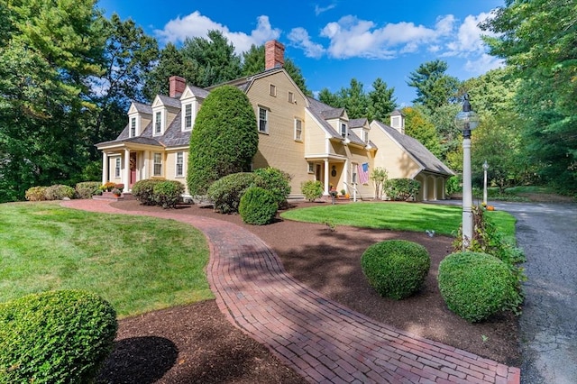 cape cod home with a front yard