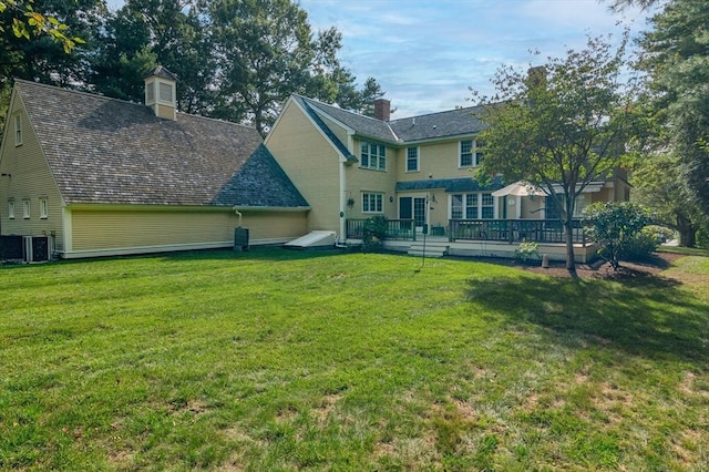 back of house with central air condition unit, a lawn, and a wooden deck