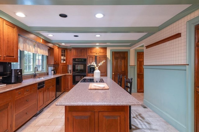 kitchen featuring a kitchen island, black appliances, sink, and crown molding