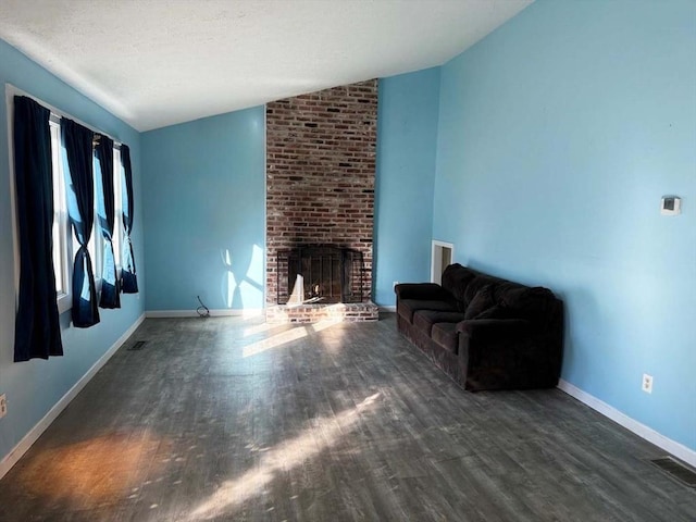 unfurnished living room with a fireplace, vaulted ceiling, and dark wood-type flooring