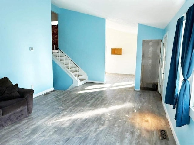 unfurnished living room featuring hardwood / wood-style flooring and vaulted ceiling