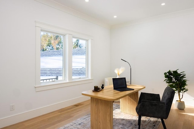 office space with ornamental molding and light wood-type flooring