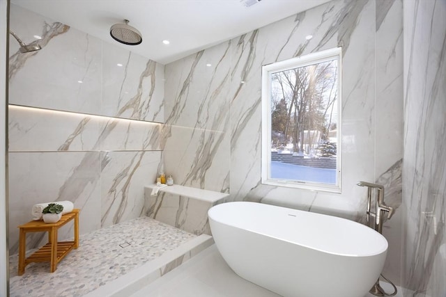 bathroom with a wealth of natural light, tile walls, and independent shower and bath