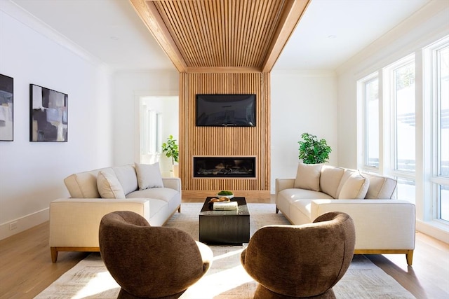 living room featuring a large fireplace, light hardwood / wood-style flooring, and ornamental molding