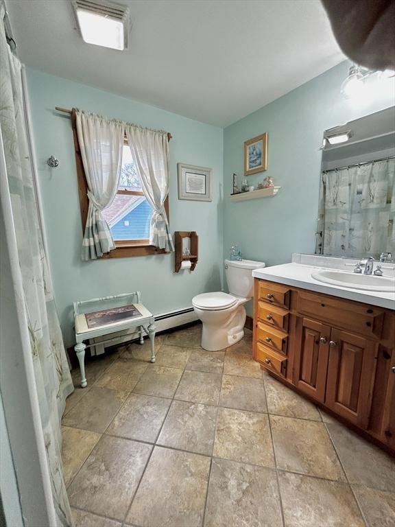 full bath featuring a shower with curtain, toilet, and vanity