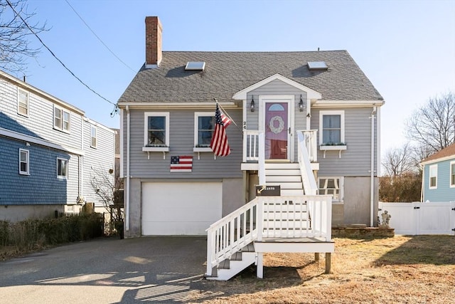 view of front of house featuring aphalt driveway, fence, a shingled roof, a garage, and a chimney