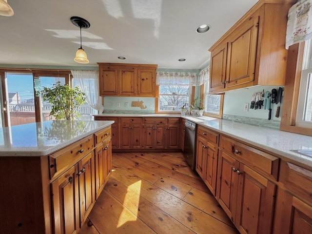 kitchen with a wealth of natural light, light wood-style floors, dishwasher, and brown cabinetry