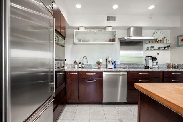 416 Commonwealth Ave Unit 504, Boston, MA 02215 - kitchen with appliances with stainless steel finishes, wall chimney range hood, open shelves, a sink, and light tile patterned floors