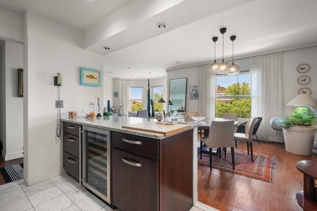 416 Commonwealth Ave Unit 504, Boston, MA 02215 - kitchen with wine cooler, dark brown cabinets, a peninsula, and hanging light fixtures