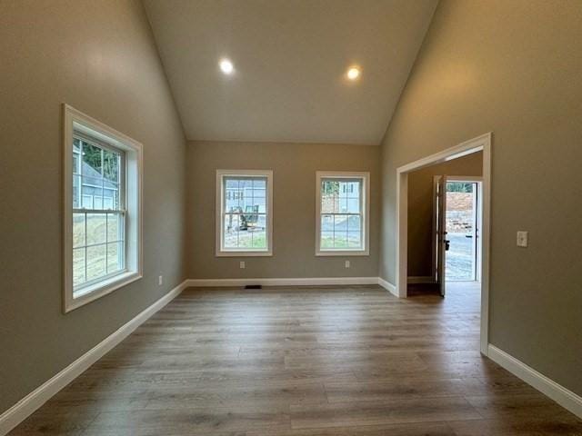 unfurnished room with baseboards, wood finished floors, and a healthy amount of sunlight