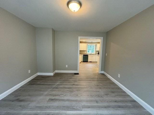 spare room featuring wood finished floors and baseboards