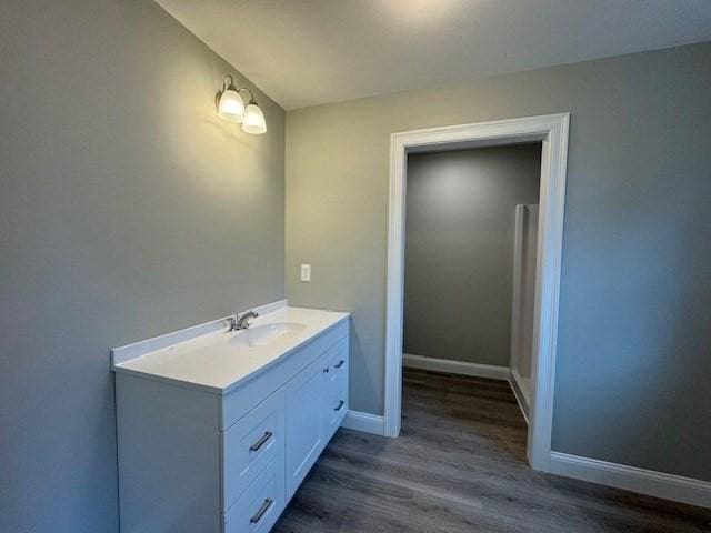 bathroom with wood finished floors, vanity, and baseboards