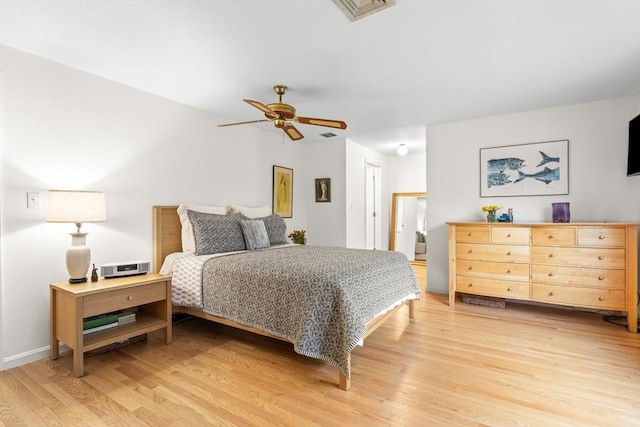 bedroom with light wood-style floors, ceiling fan, and baseboards