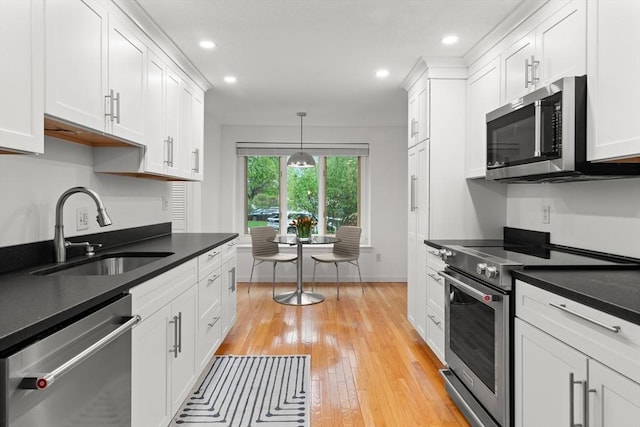 kitchen featuring stainless steel appliances, a sink, white cabinetry, and recessed lighting