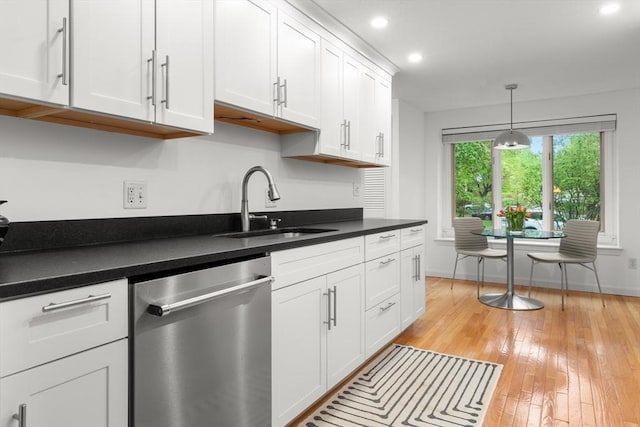 kitchen featuring dishwasher, a sink, white cabinets, dark countertops, and recessed lighting