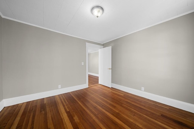 empty room featuring baseboards, wood-type flooring, and ornamental molding