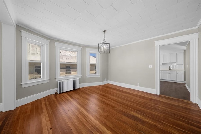 unfurnished dining area featuring dark wood-style floors, radiator, baseboards, and ornamental molding