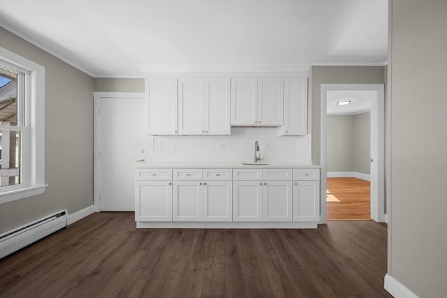 kitchen with a sink, dark wood finished floors, white cabinetry, light countertops, and baseboard heating