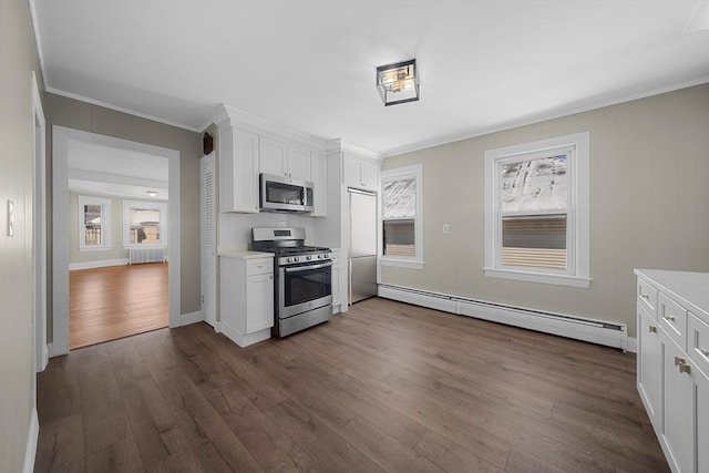 kitchen with radiator, dark wood-style floors, light countertops, appliances with stainless steel finishes, and a baseboard heating unit